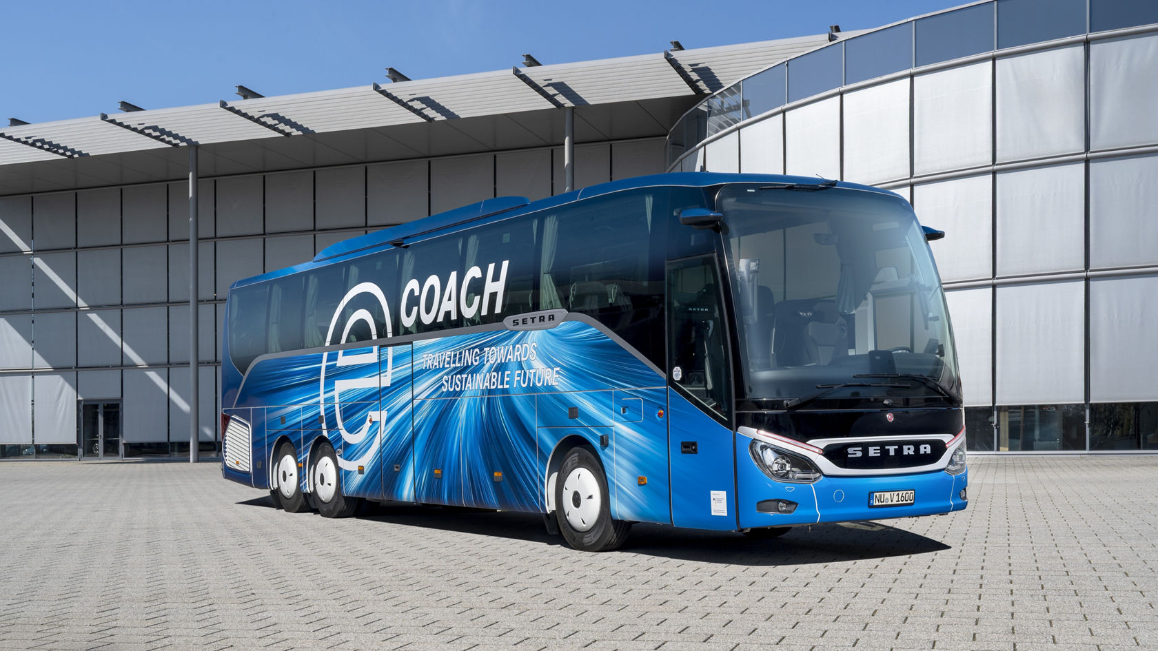 Blue Setra Comfort Class touring coach with “eCoach” lettering in front of Setra headquarters, side view outside