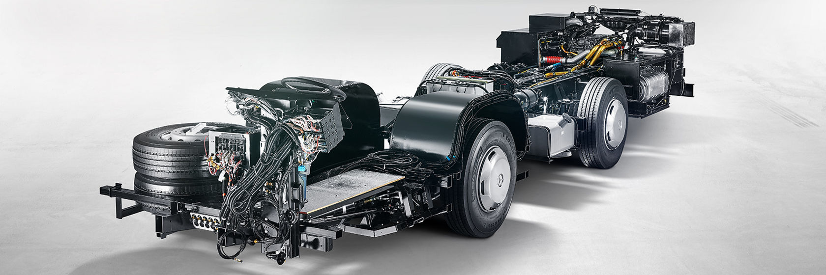 Mercedes-Benz OC 500 LE bus chassis with exposed drivetrain, high-voltage cables and components on studio background