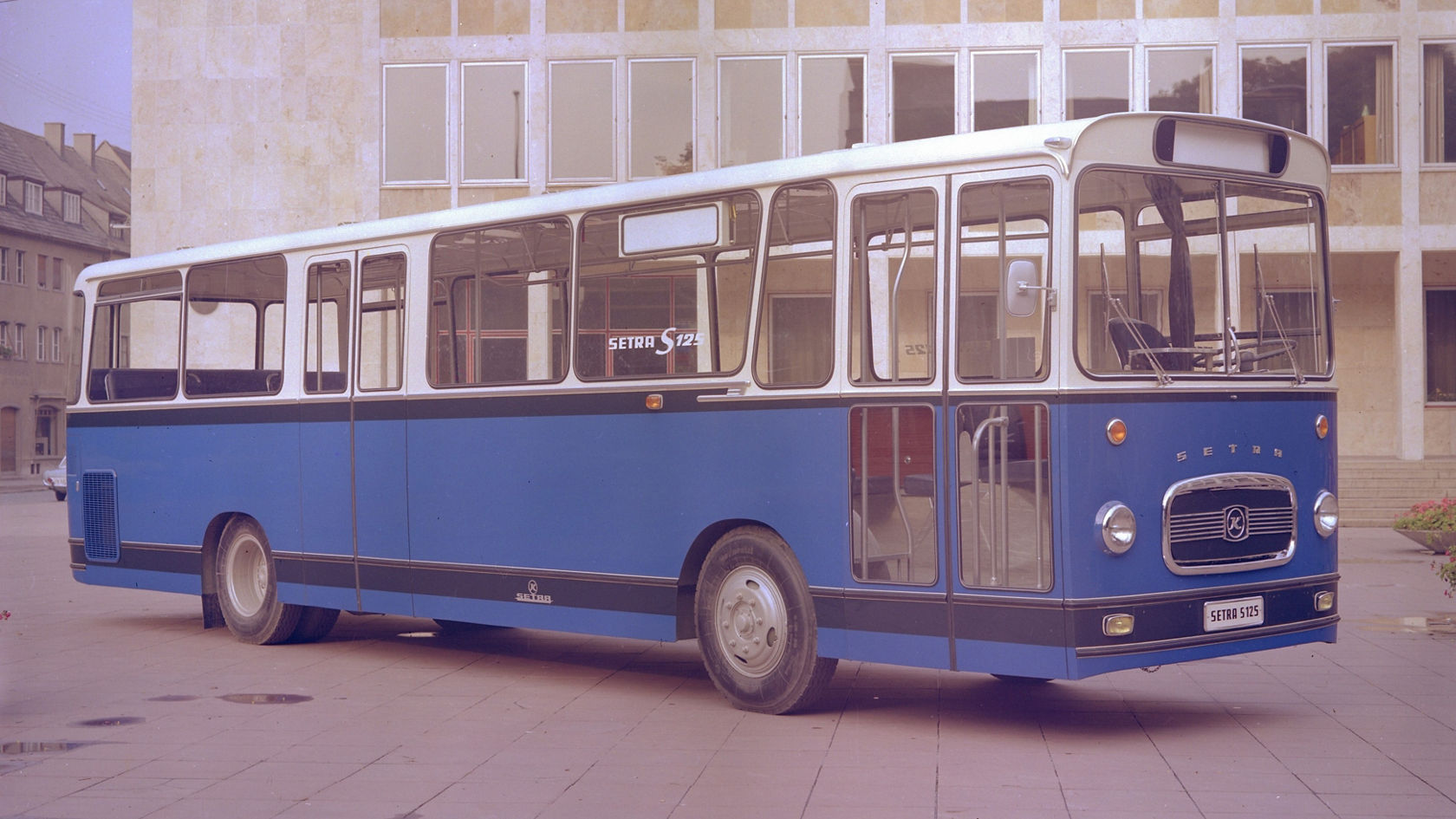 Historic Setra S 125 scheduled-service bus in blue and white, slanted front view in front of an office building