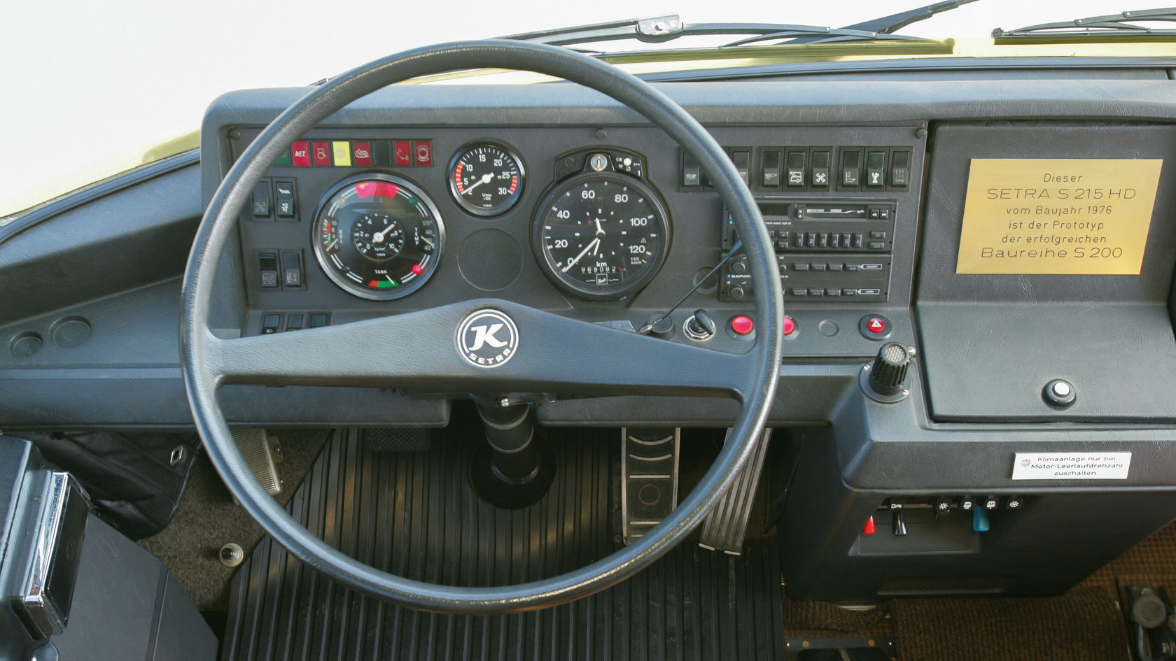 Driver cockpit in the Setra touring coach with steering wheel, speedometers, switch panel and note “Setra S 215 HD, year of manufacture 1976, model series S 200”