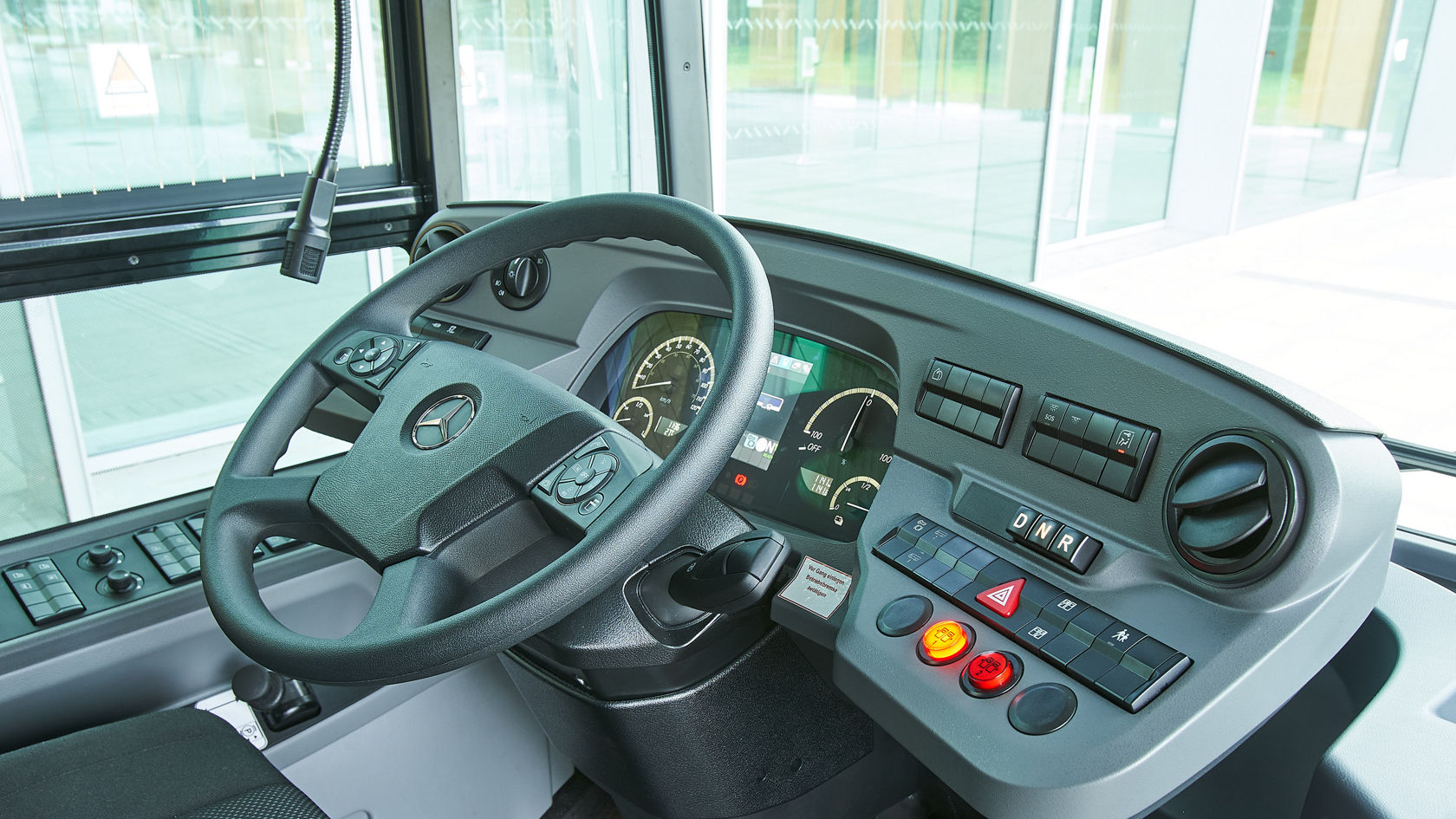 Fahrerarbeitsplatz im Mercedes-Benz eCitaro mit Lenkrad, digitalem Kombiinstrument und Bedienelementen am Cockpit