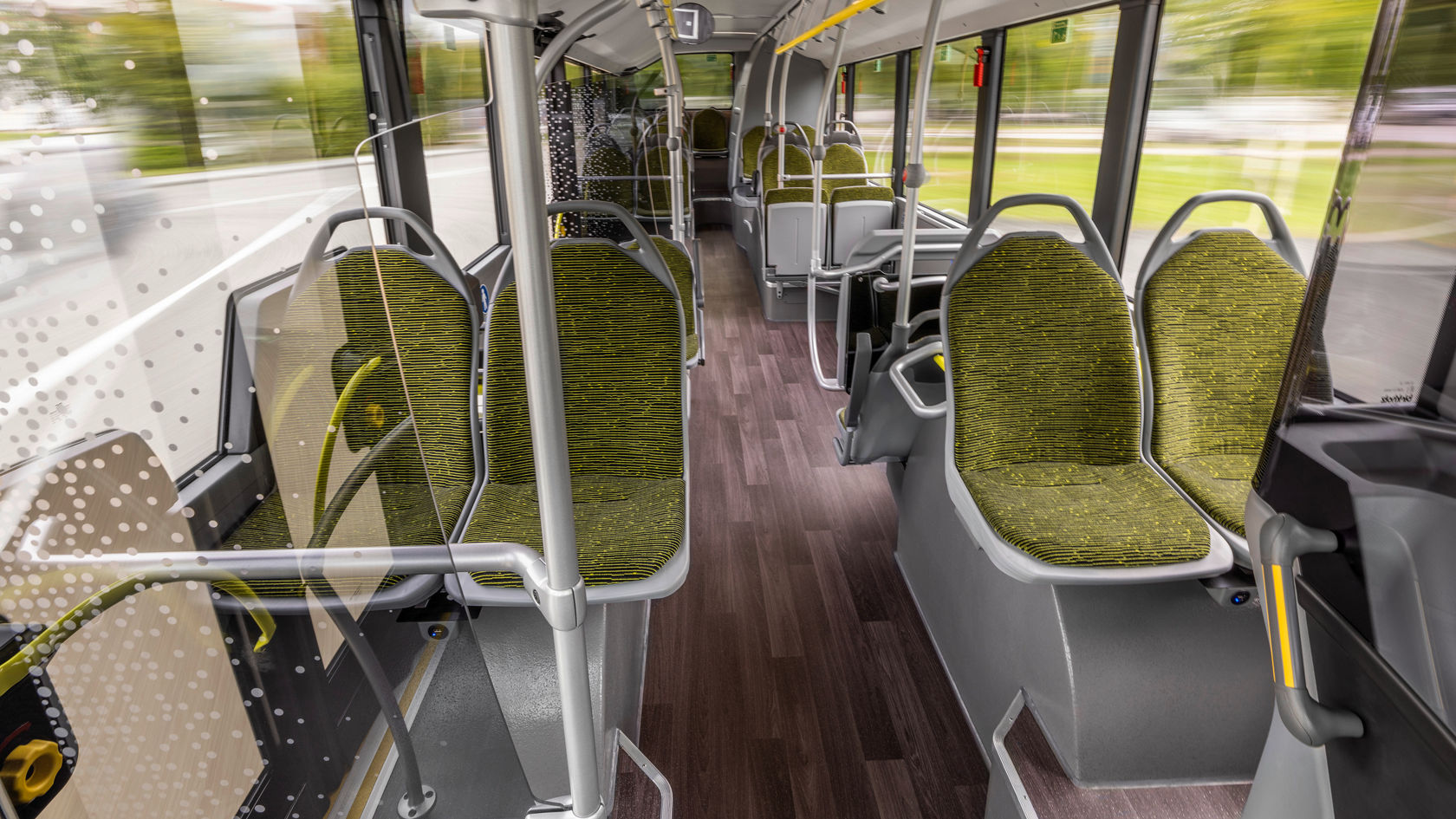 Innenraum eines Mercedes-Benz eCitaro mit barrierefreiem Mittelgang, grünen Sitzpolstern und großen Panoramafenstern
