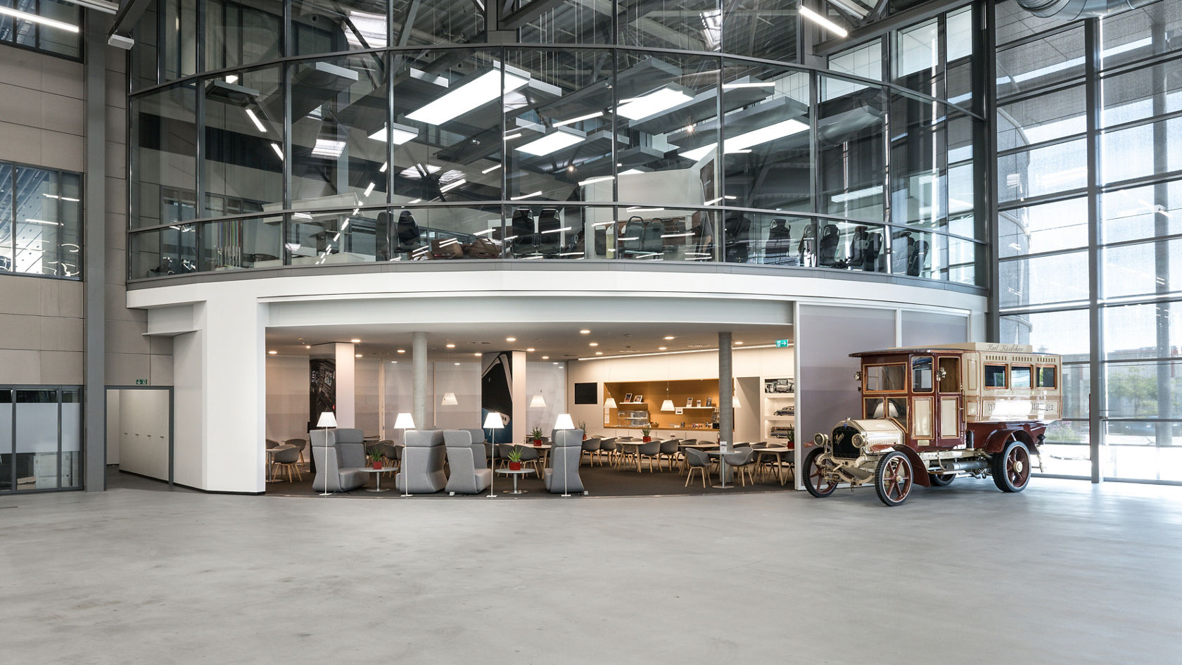 Vista dal capannone di consegna sul Centro Clienti Setra con moderna zona lounge, galleria e veicolo storico in esposizione.