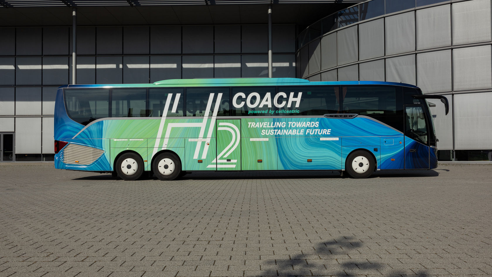 Setra H2 Coach touring coach with hydrogen drive in side view in front of a modern building, decals with H2 design graphic