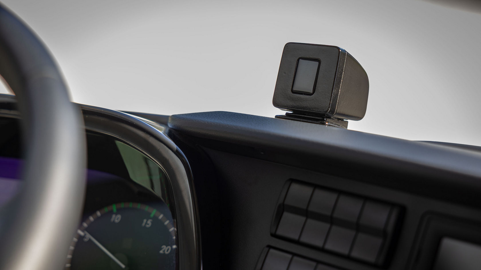 Compact interior camera on the instrument panel of a bus.