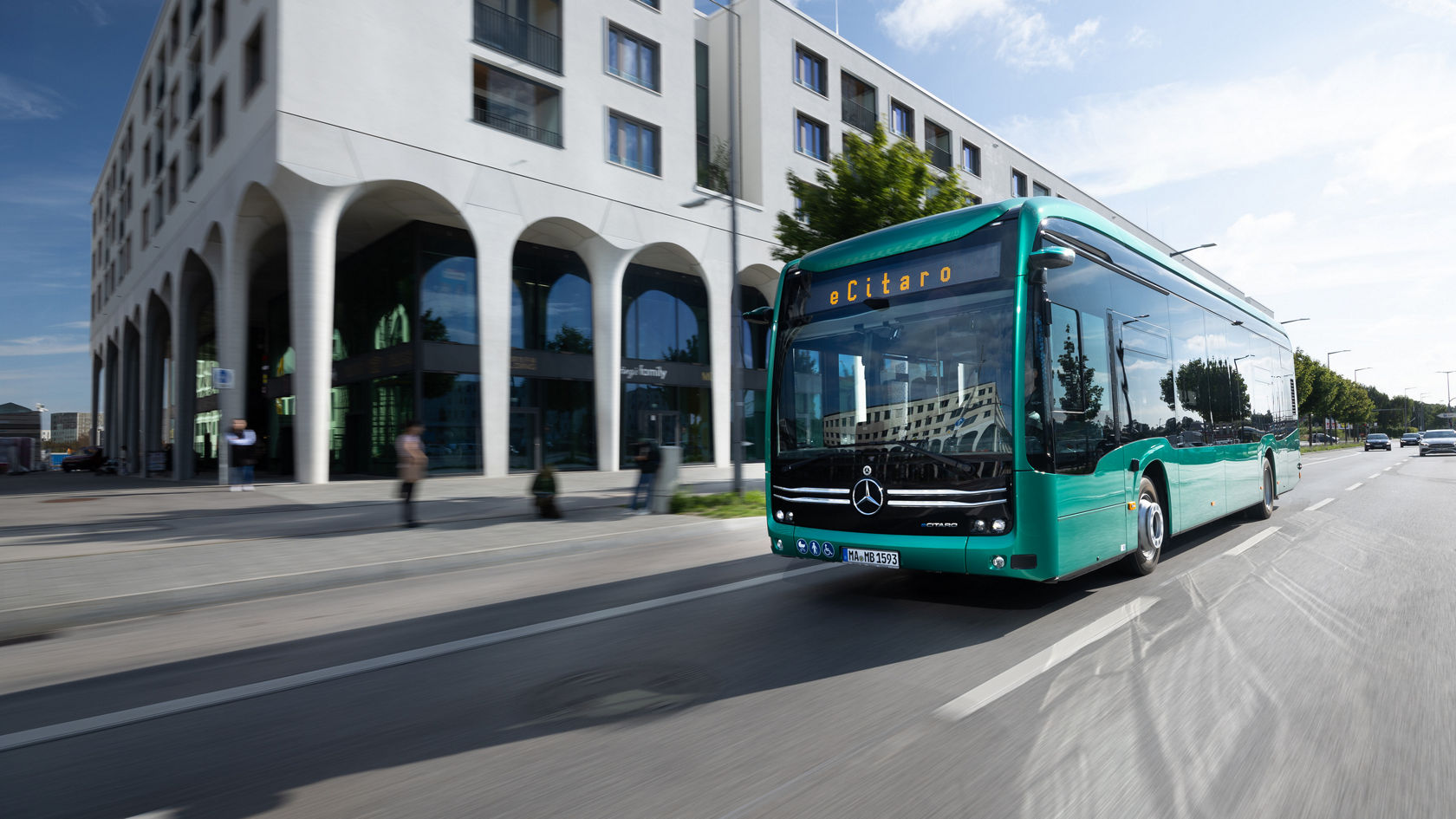 Mercedes-Benz eCitaro electric city bus driving past modern buildings on a city road