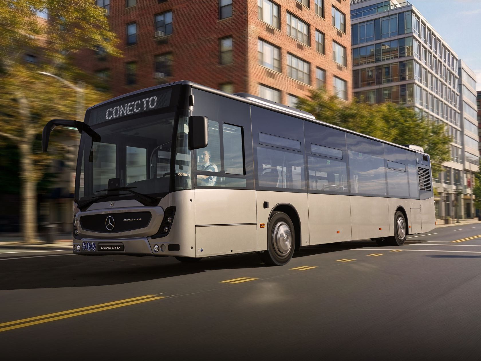 Gradski autobus Mercedes-Benz Conecto u urbanom saobraćaju prolazi pored modernih stambenih i kancelarijskih zgrada.