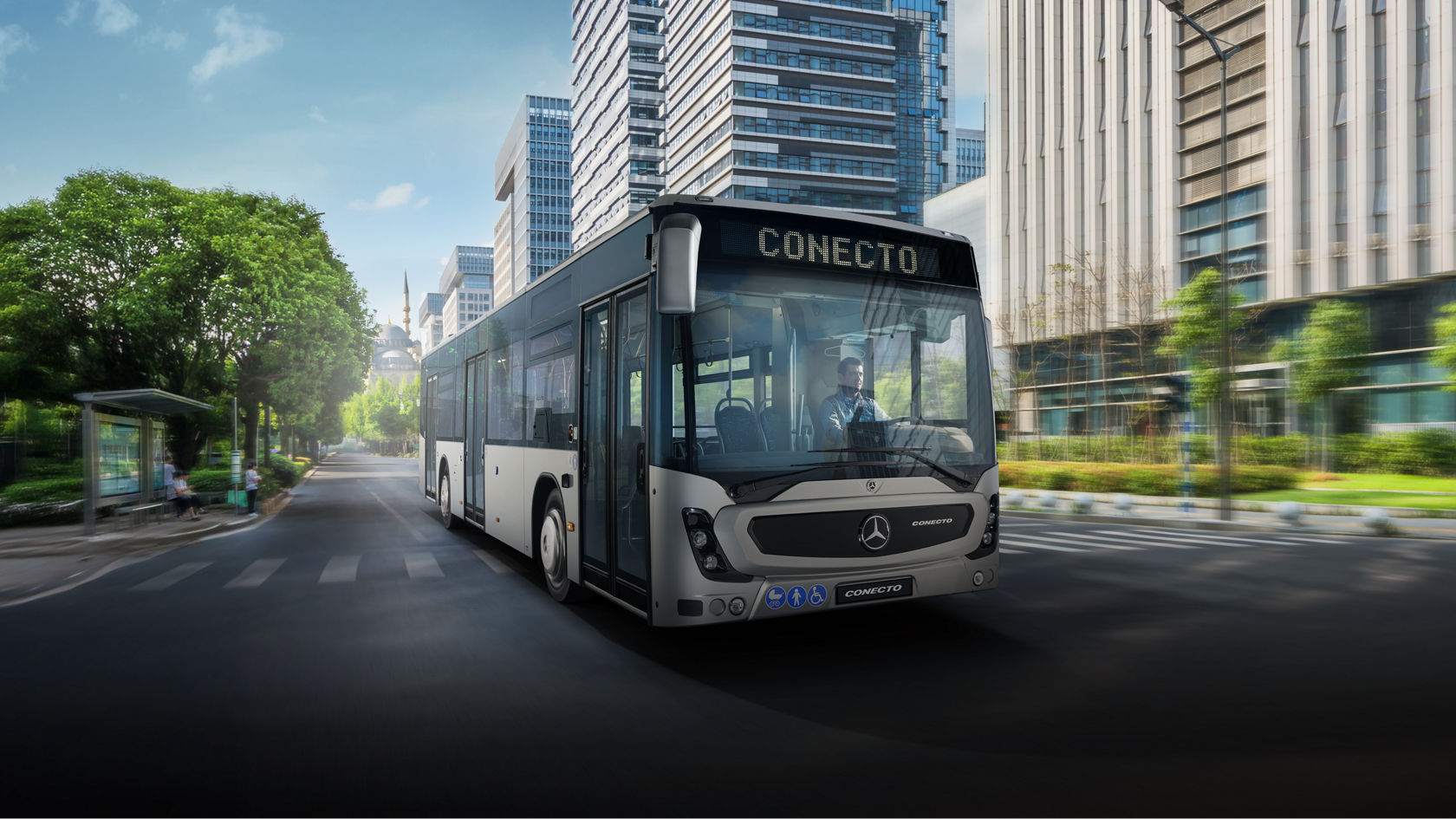 Moderni Mercedes-Benz Conecto gradski autobus putuje kroz zeleni centralni grad sa modernim kancelarijama i urbanom infrastrukturom.