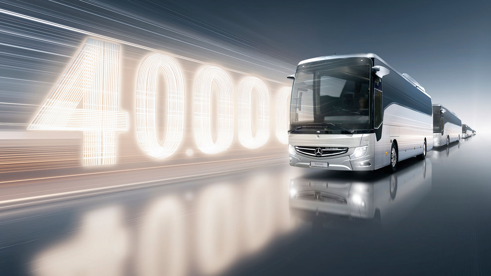 Mercedes-Benz Tourrismo touring coach in front of bright “40,000” graphic with several buses in a row on a mirrored surface