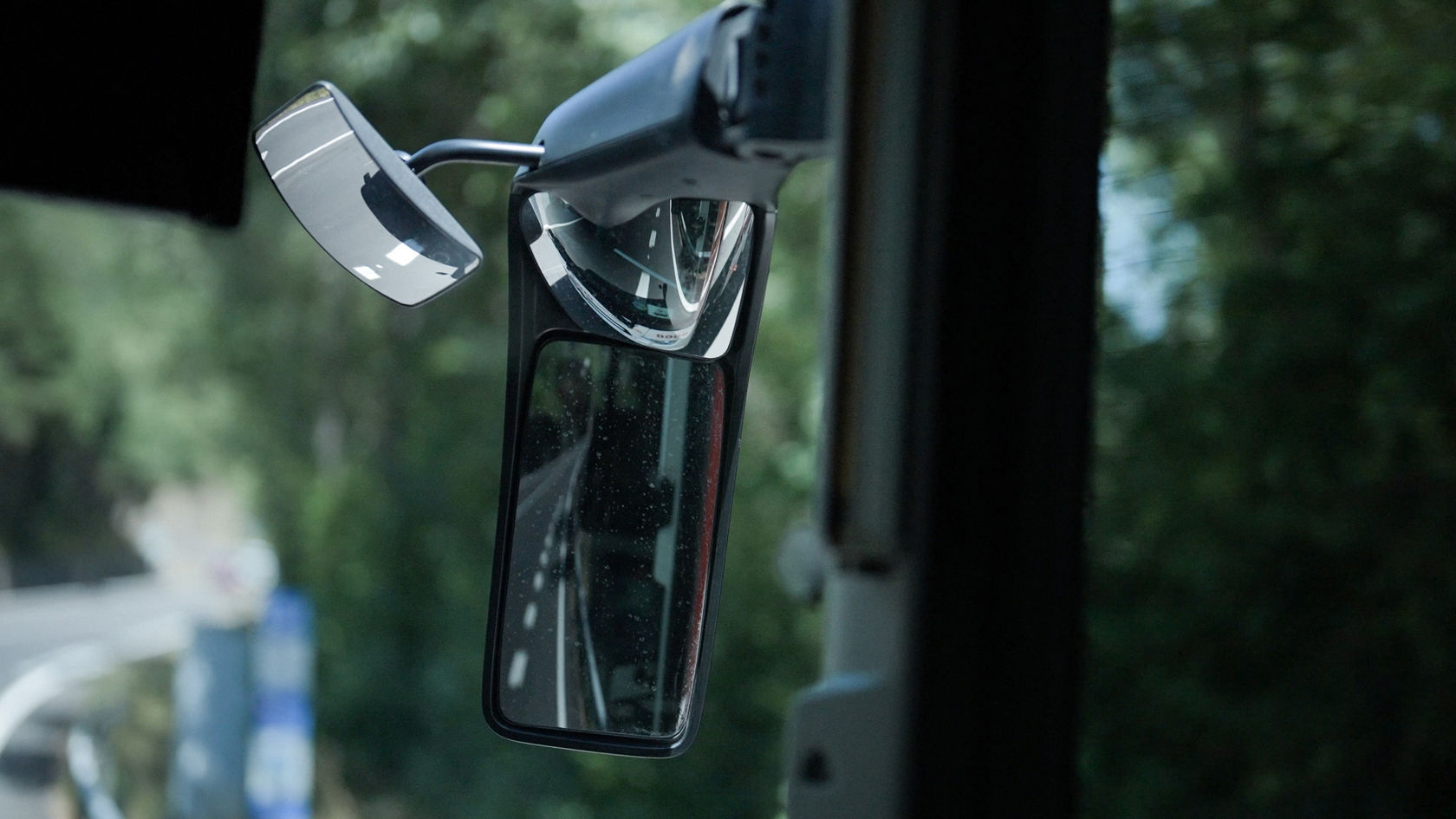 Sicherheitsrelevanter Außenspiegel am Mercedes-Benz Bus Intouro für optimale Übersicht auf kurvigen Straßen.