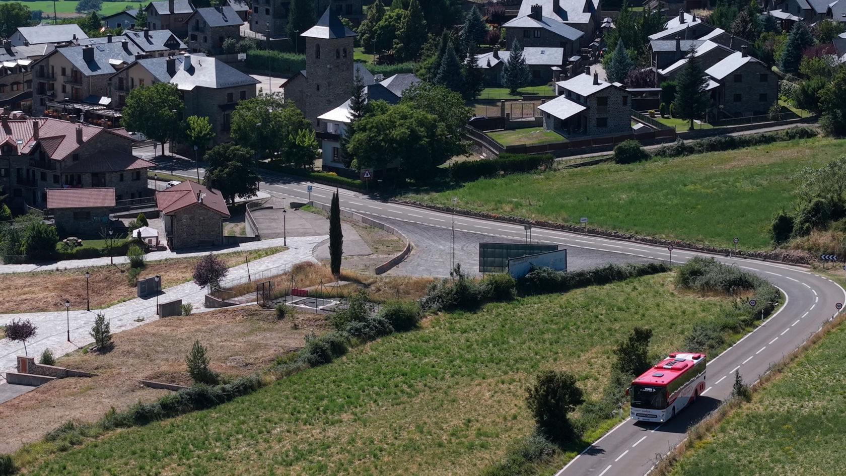 Mercedes-Benz Überlandbus Intouro auf einer Landstraße  nahe einer Ortschaft in ländlicher Bergregion.