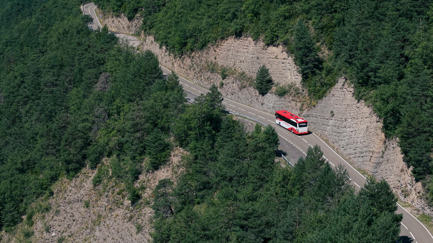 Mercedes-Benz Überlandbus Intouro auf einer schmalen Bergstraße im Überlandverkehr durch bewaldetes Gebirge.