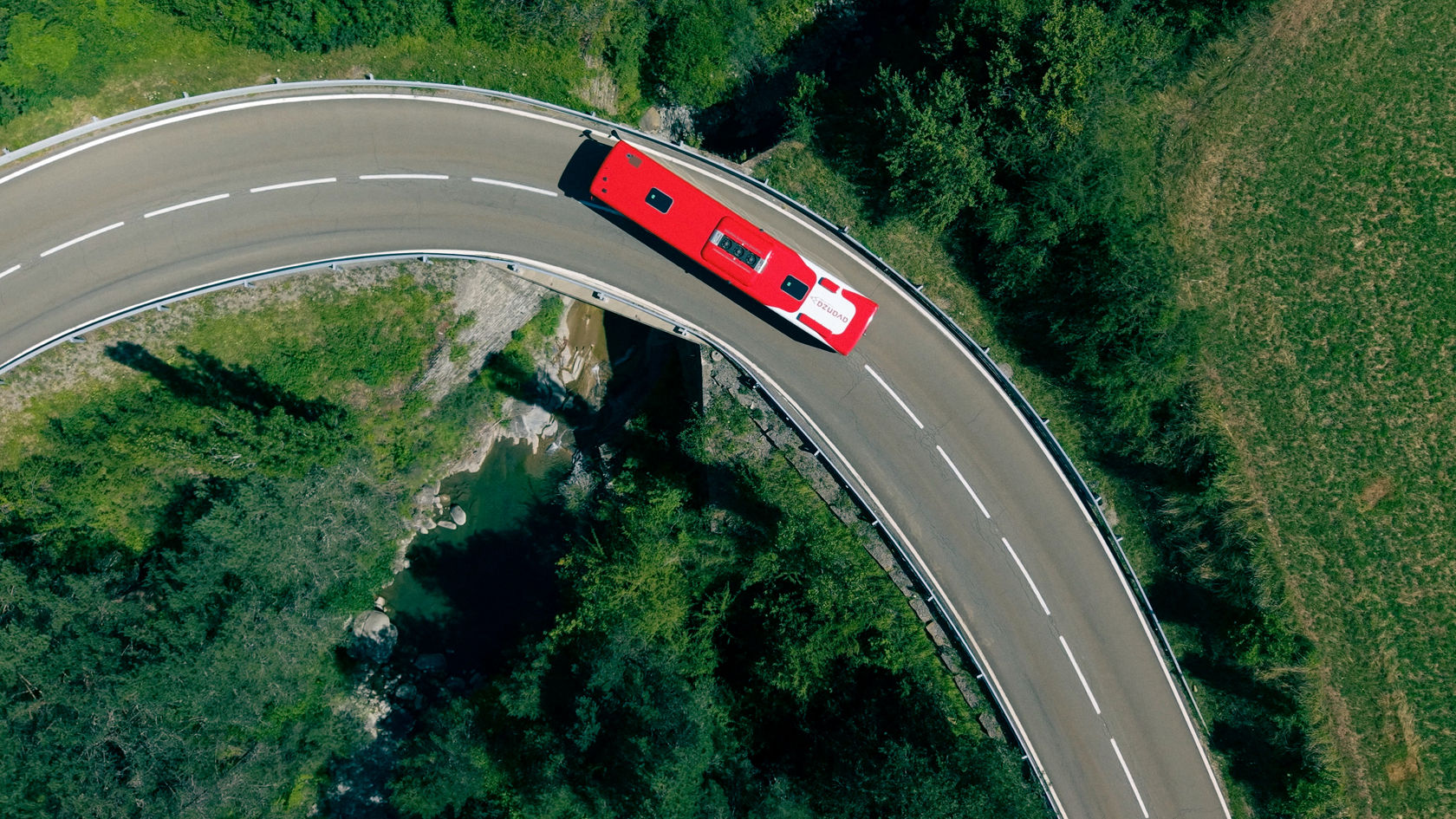 Mercedes-Benz Überlandbus Intouro auf einer kurvigen Bergpassstraße, aufgenommen aus der Vogelperspektive.