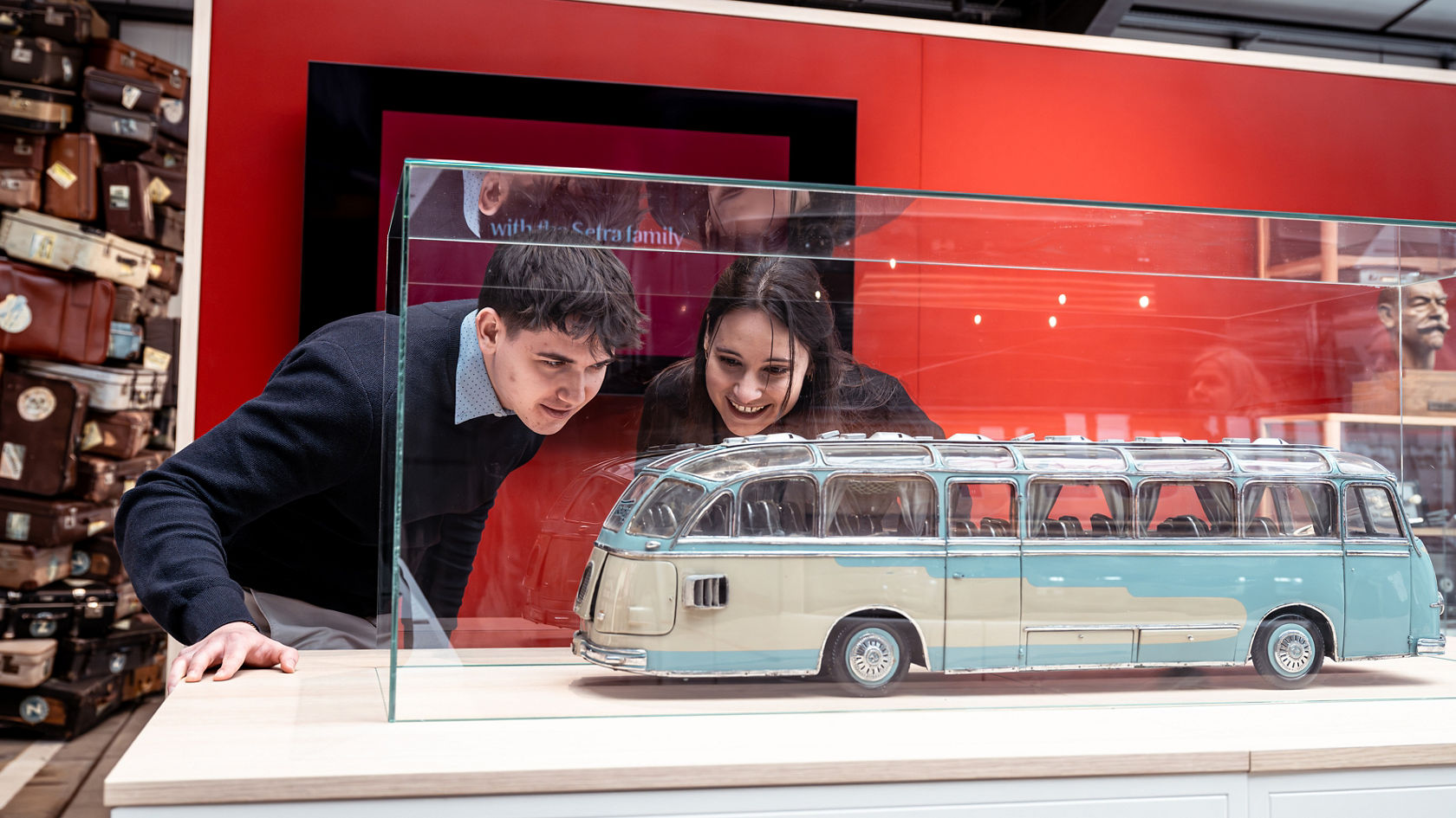 Twee bezoekers bekijken in de Kässbohrer Halle een historisch Setra busmodel in een glazen vitrine