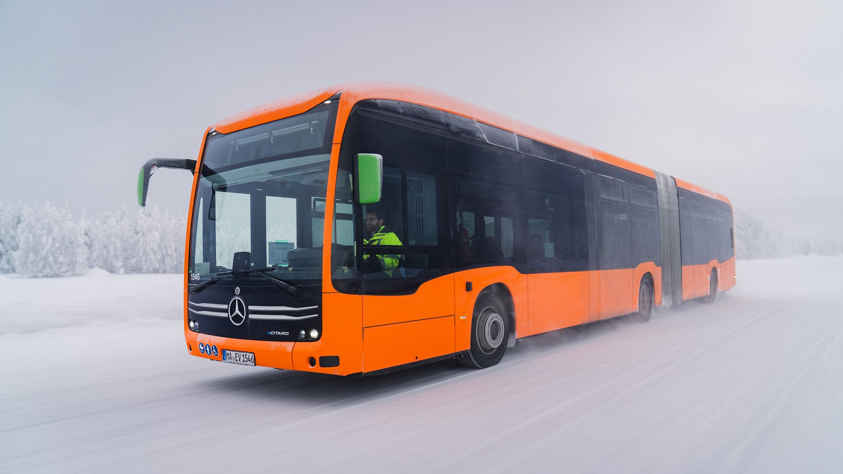 L’autobus articulé Mercedes-Benz eCitaro orange roule sur une piste d’essai hivernale enneigée