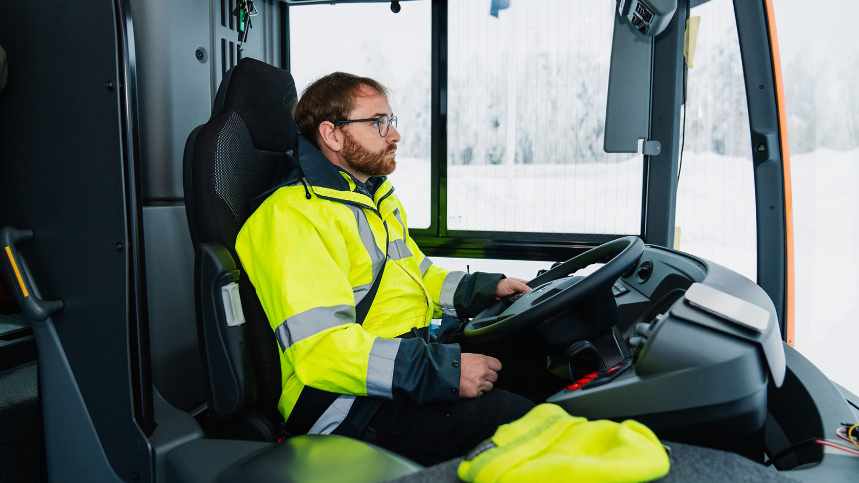 Poste de conduite dans un bus Mercedes-Benz avec volant et poste de conduite, conducteur au volant en veste de sécurité