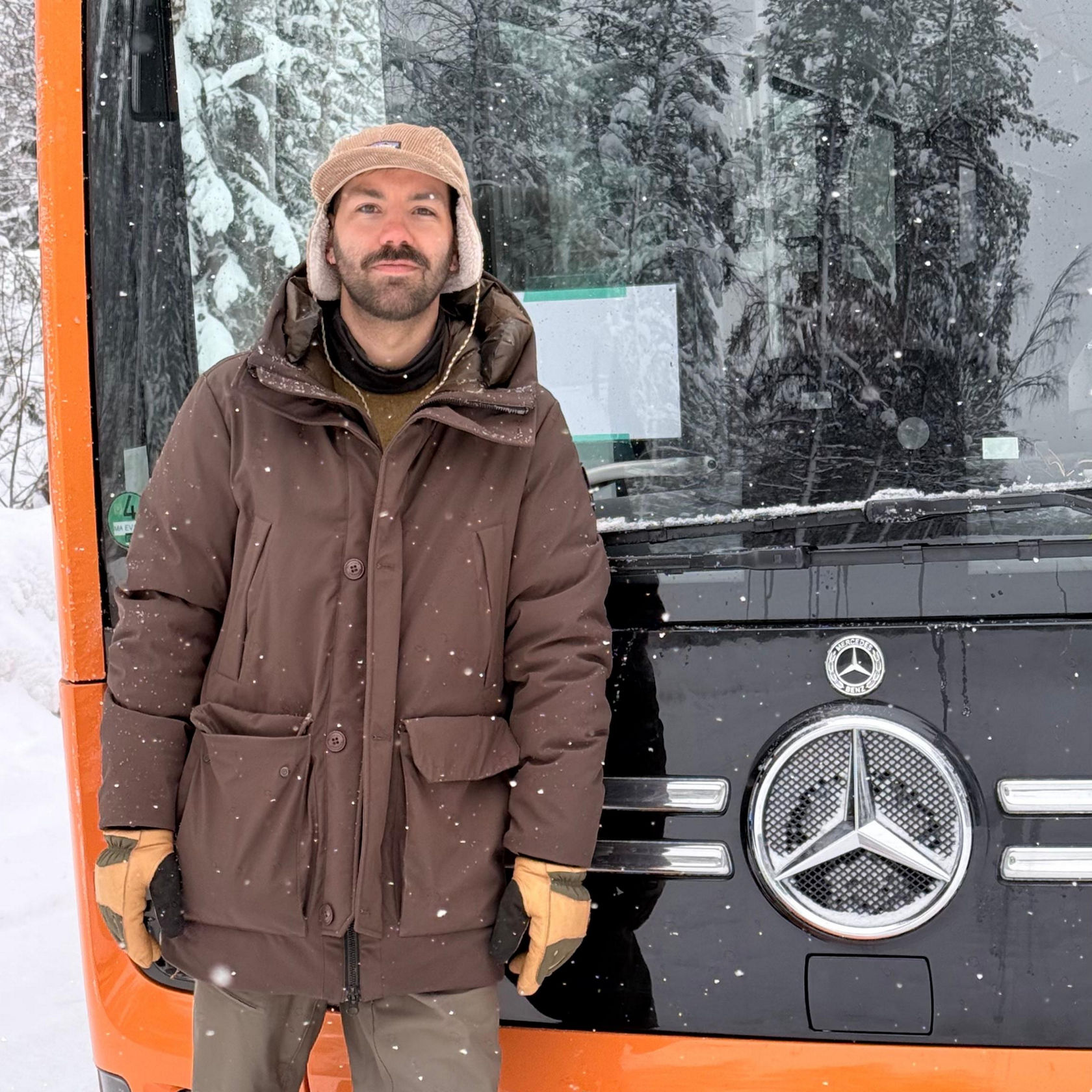Ingénieur d’essai de Daimler Buses en tenue d’hiver devant un Mercedes-Benz eCitaro avec l’emblème de l’étoile en cas de chute de neige