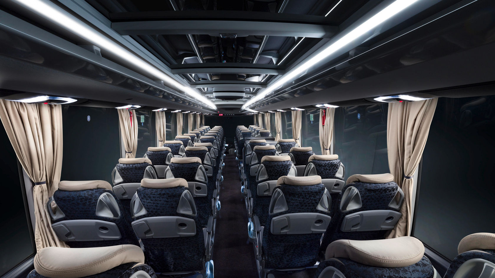 Interno di un Autobus da turismo Setra TopClass con file di sedili, corridoio centrale, vani portabagagli e listelli luminosi a LED lungo il soffitto