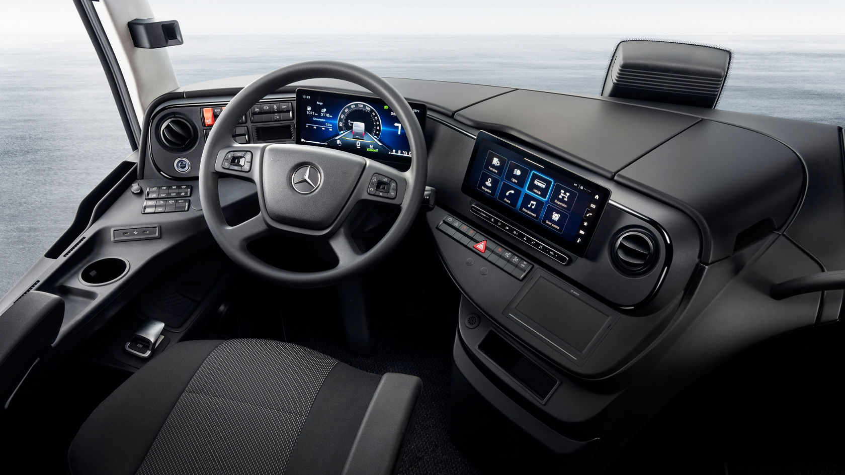 Poste de conduite dans l’autocar de tourisme Mercedes-Benz Tourismo avec volant, combiné d’instruments numérique et écran tactile central dans le poste de conduite