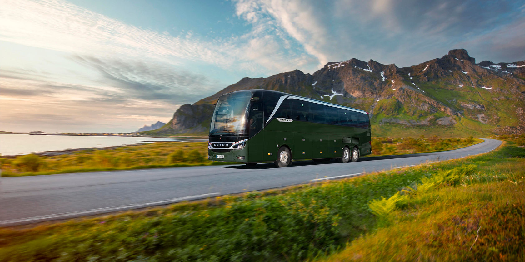 Autobus da turismo verde Setra TopClass 500 su strada extraurbana davanti a un panorama montano e costiero