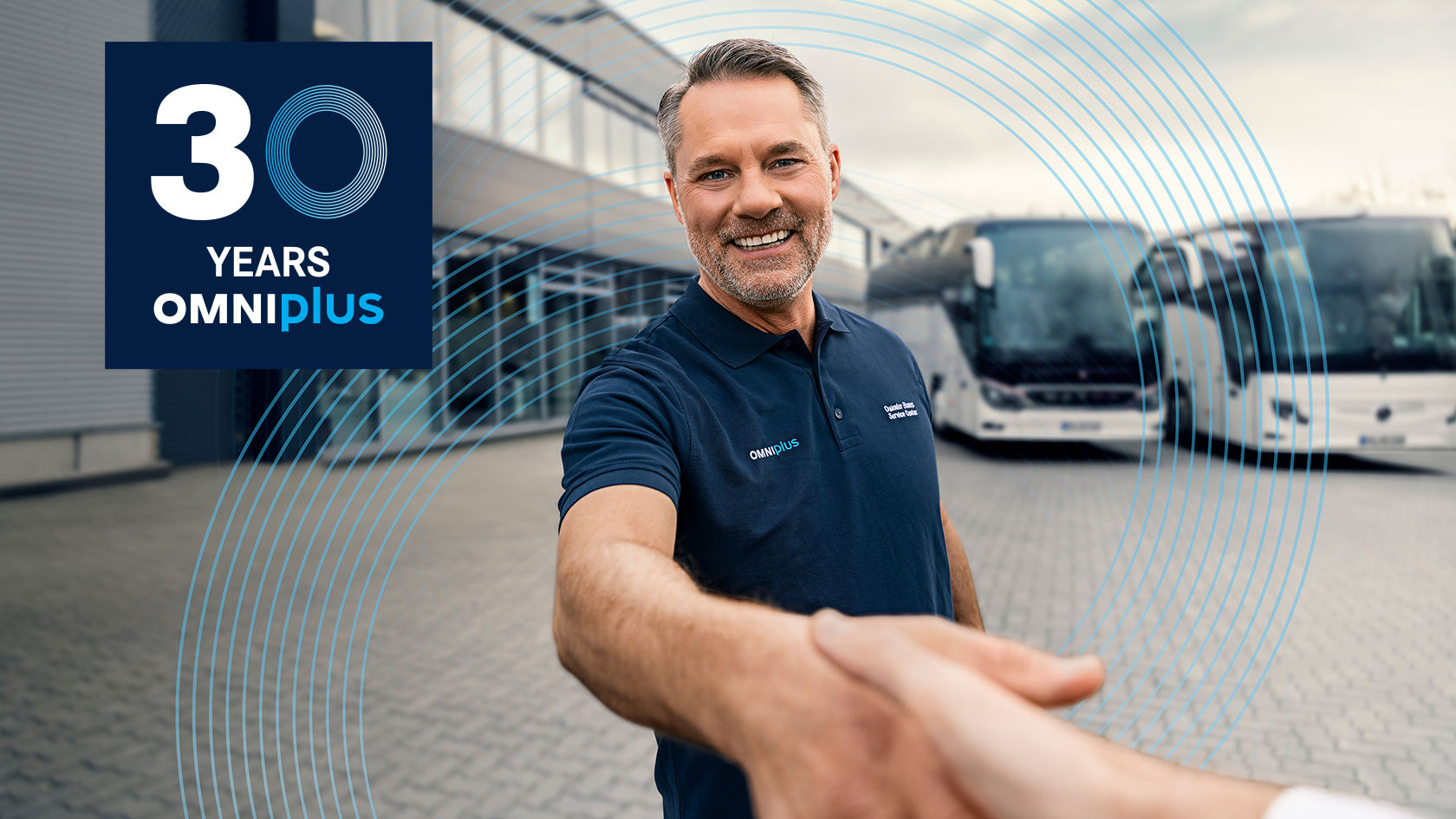 Handshake between two people at a bus depot with parked Setra and Mercedes-Benz buses in the background.
